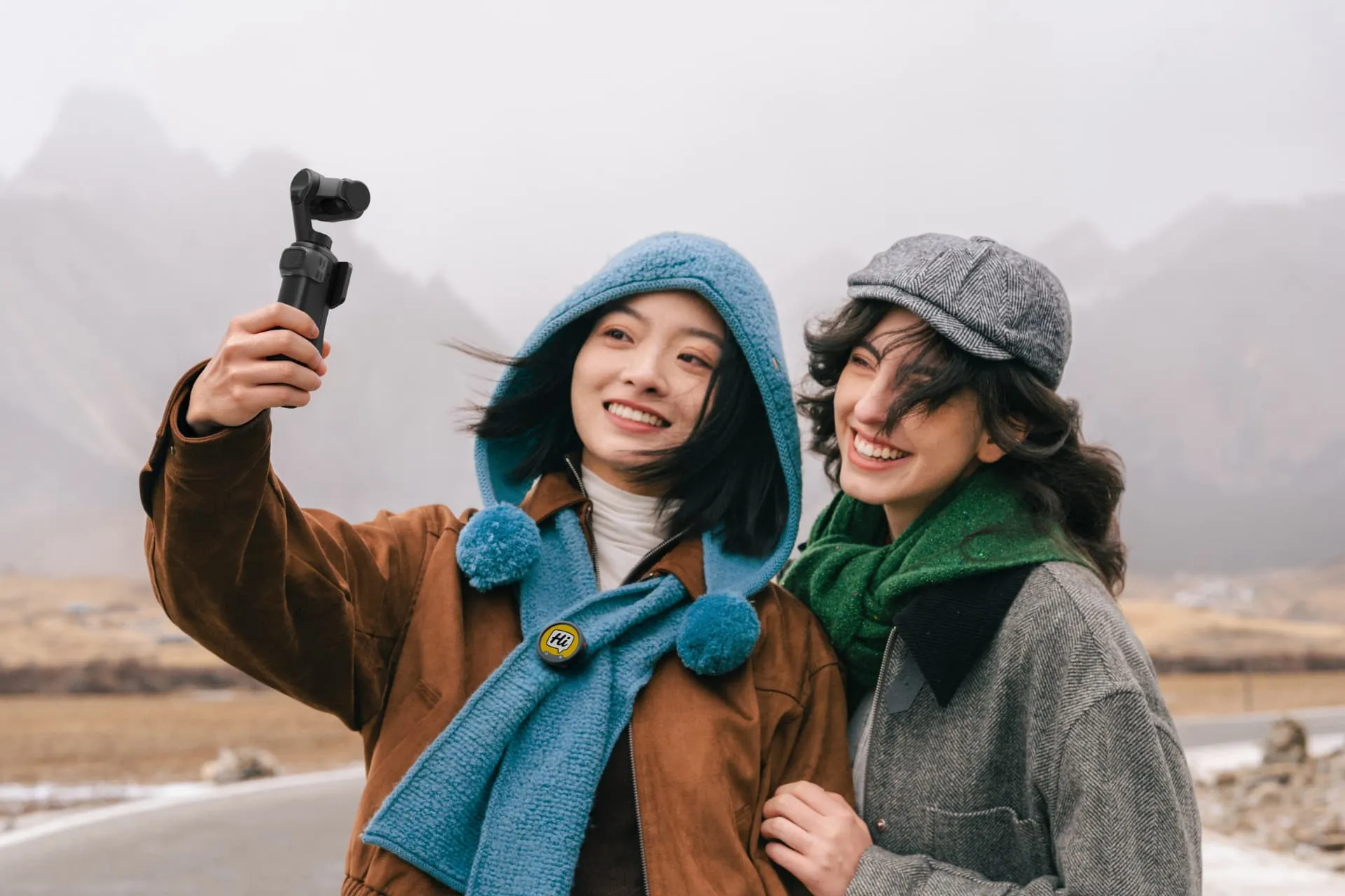 To veninder filmer selfie med Luna Ultra i tåget bjerglandskab